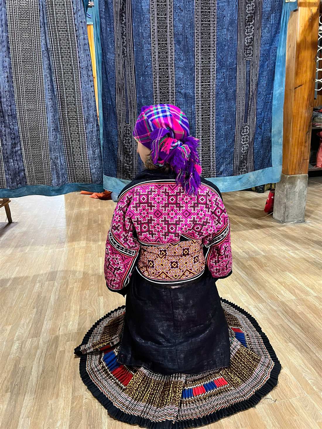 Hmong woman in pink embroidered jacket, view from behind